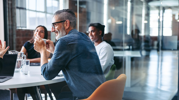 Colleagues having a meeting and smiling together around a table