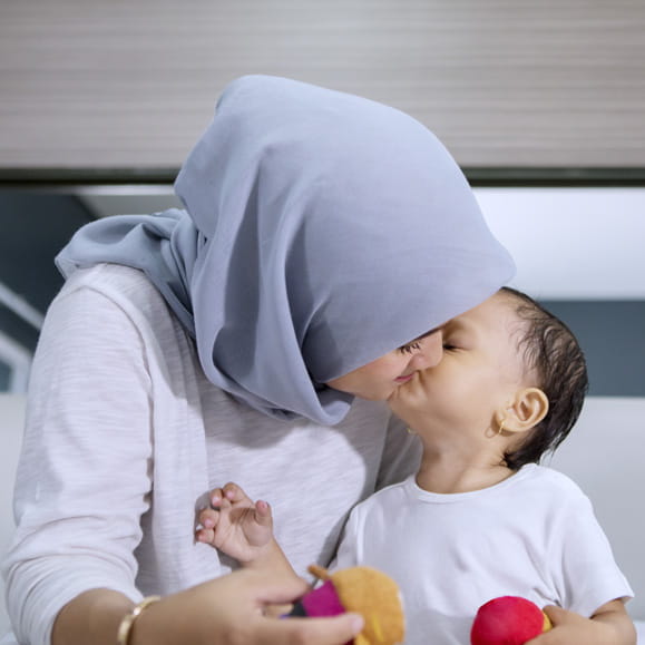 Young child giving mother a kiss on the cheek