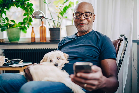Person reading mobile phone with a puppy on their lap
