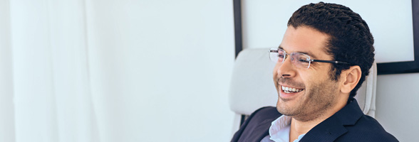 man sitting in a chair looking confident in business attire