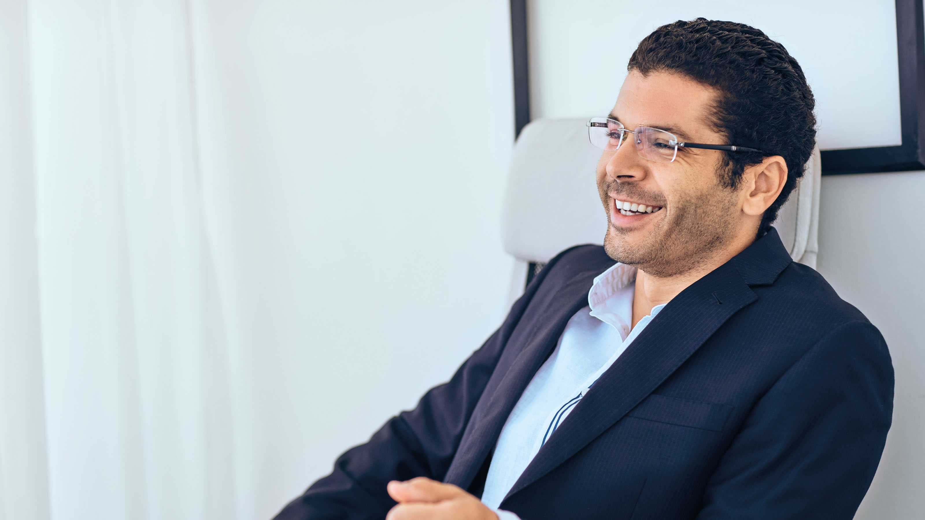 man sitting in a chair looking confident in business attire