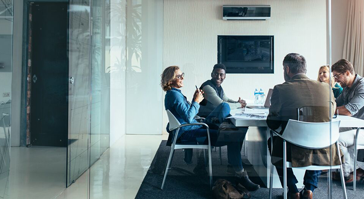 Colleagues sat down collaborating at meeting room table